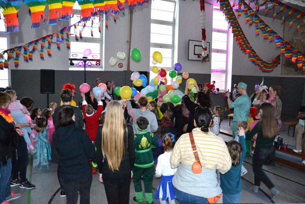 tanzende Kinder vor einem DJ Pult mit Luftballons