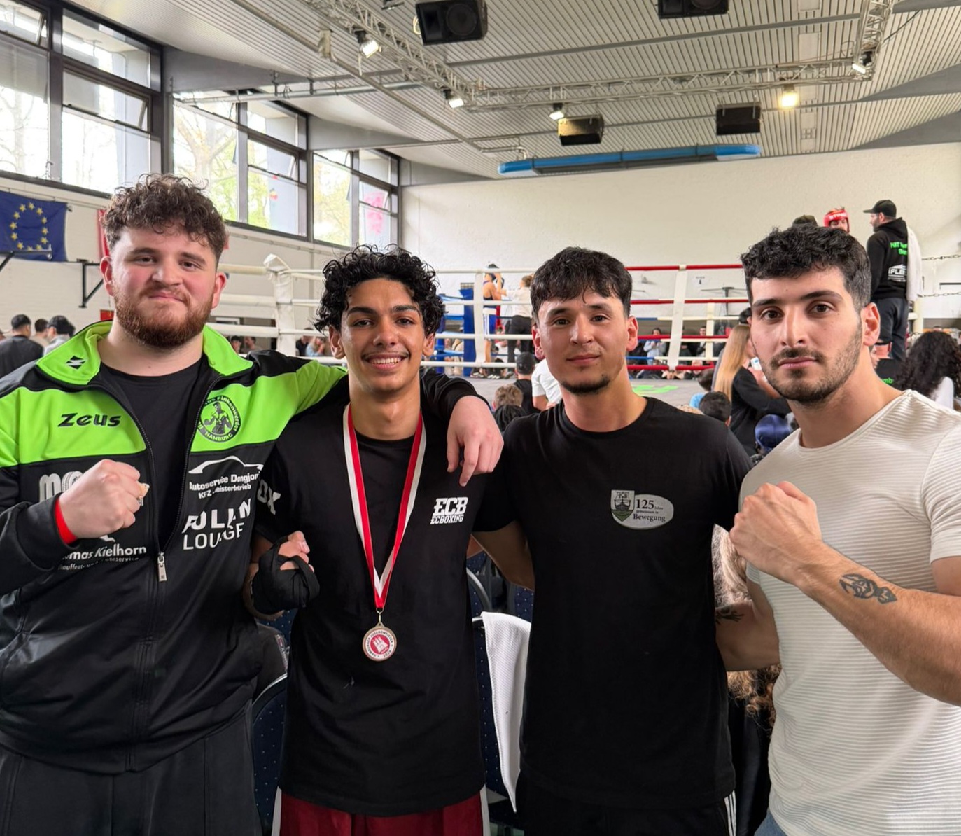 Gruppenfoto und in der Mitte ist der Kämpfer mit Medaille