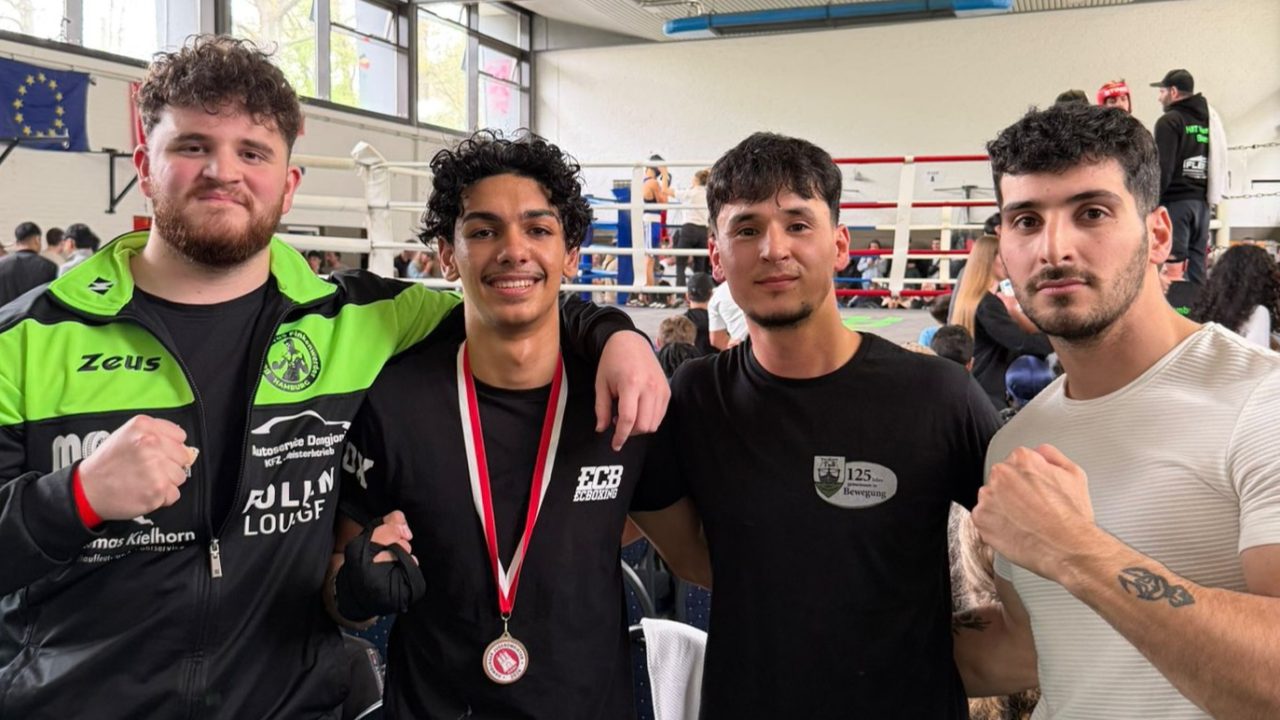 Gruppenfoto und in der Mitte ist der Kämpfer mit Medaille