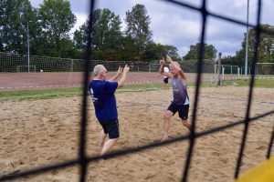 Ein Duo der Beachvolleyball-Abteilung des TuS Finkenwerder freut sich über einen Punktgewinn und klatscht sich ab.